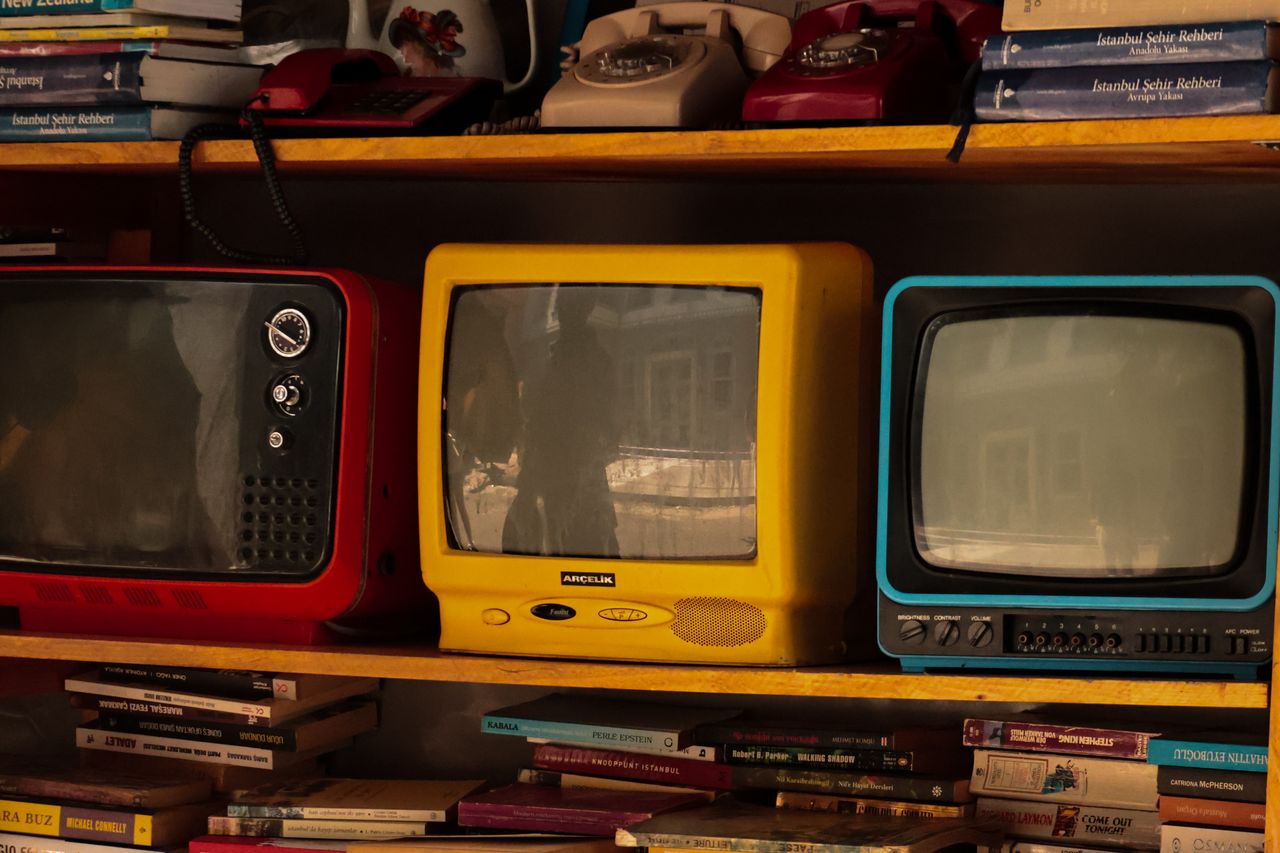 Crafting Captivating Headlines: Your awesome post title goes here A collection of vintage retro TVs and old telephones on a wooden shelf, evoking nostalgia.